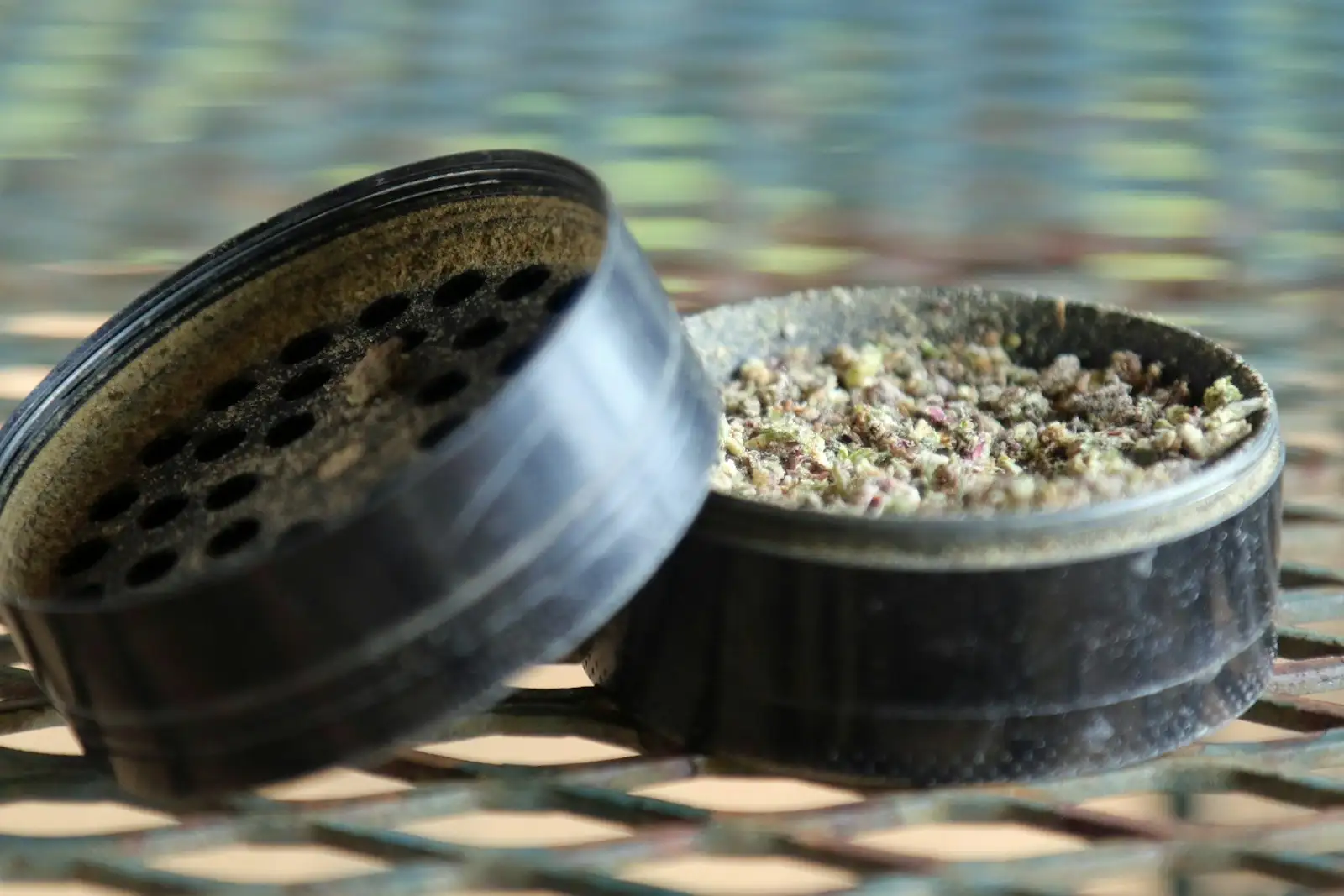 Grinder abierto en dos piezas, con la cámara llena de flor finamente triturada