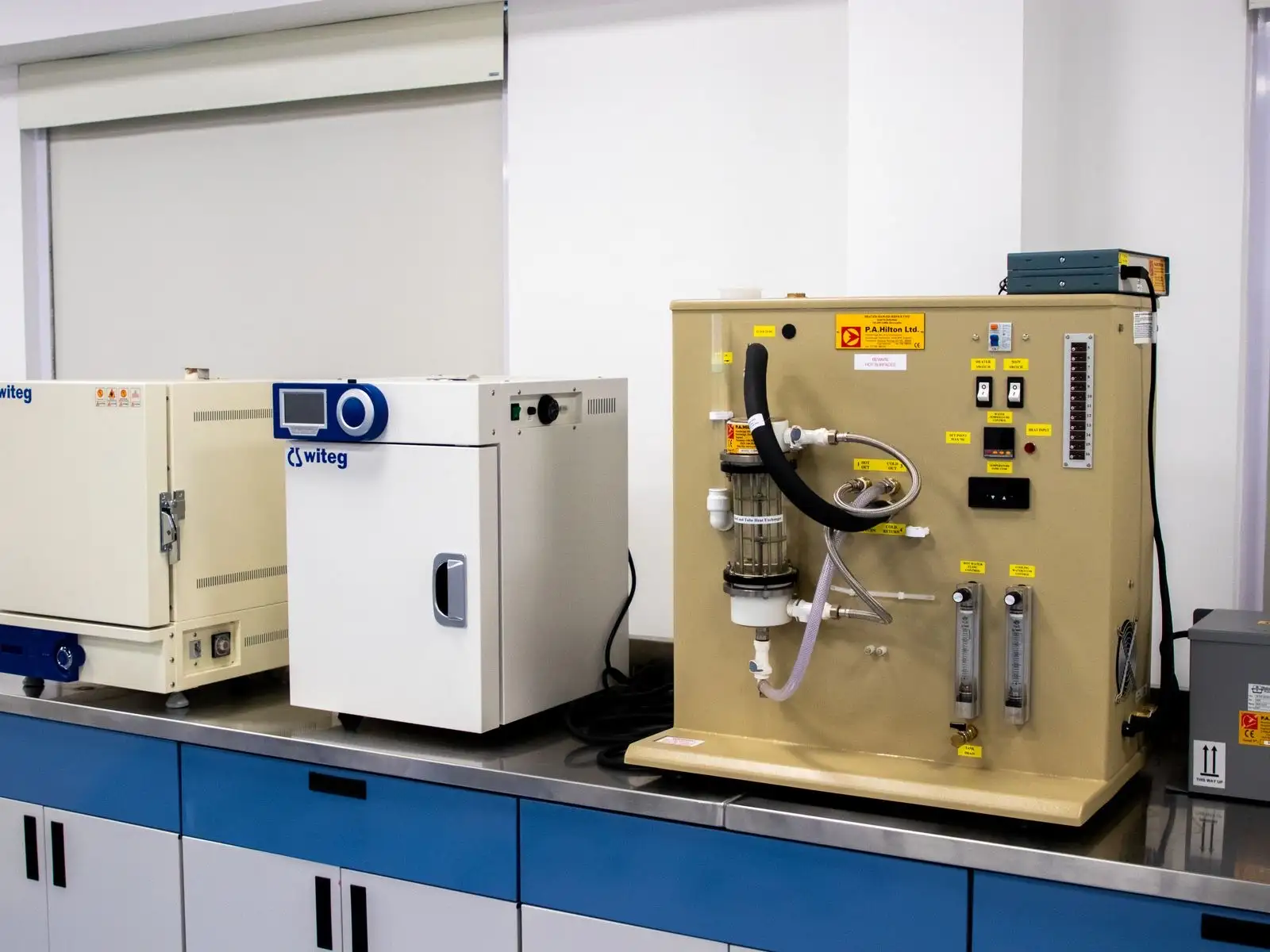 Mesa de laboratorio con estufas y un banco de ensayo con tubos y caudalímetros