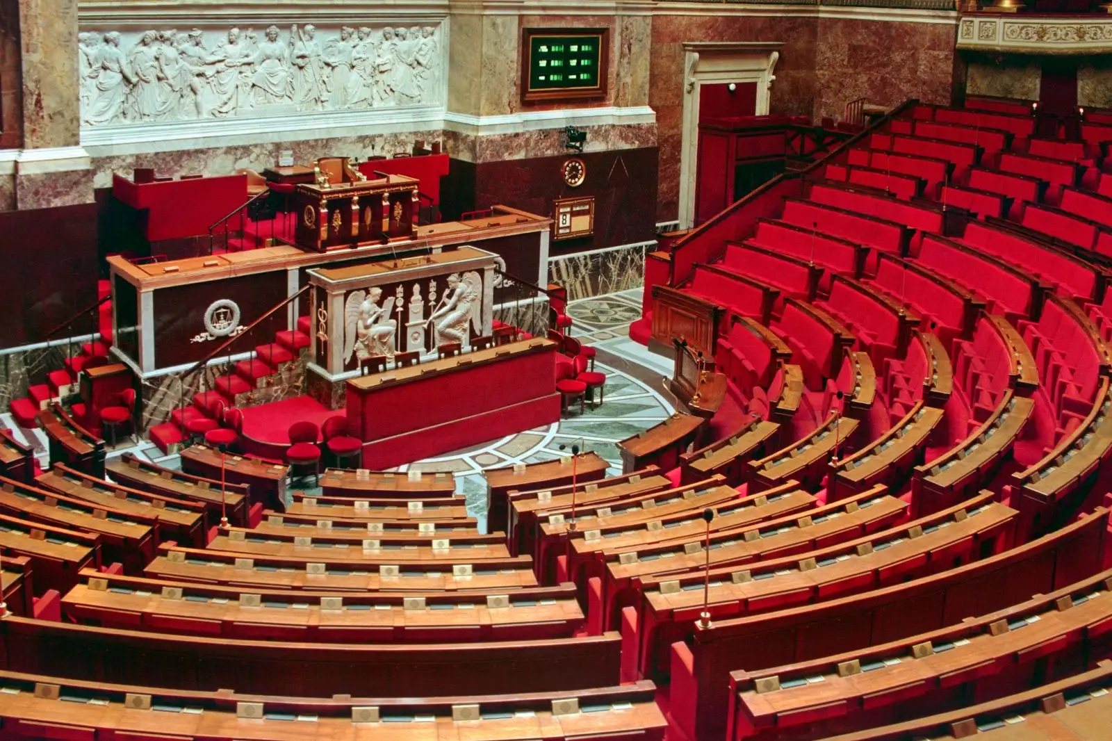Hemiciclo vacío de la Asamblea Nacional francesa, filas de asientos rojos frente a la tribuna