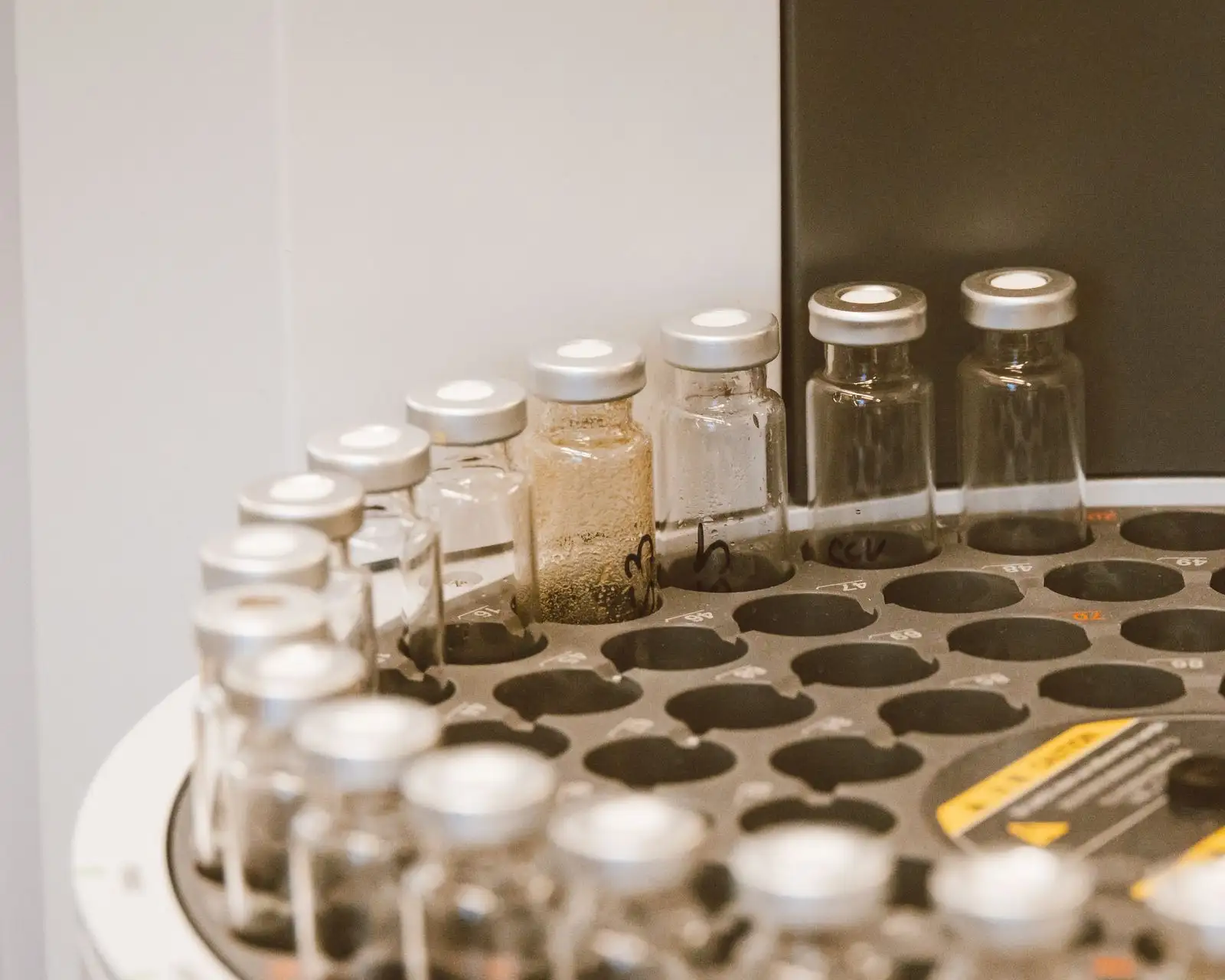 Viales de muestras tapados en la bandeja del inyector automático de un cromatógrafo, en el laboratorio