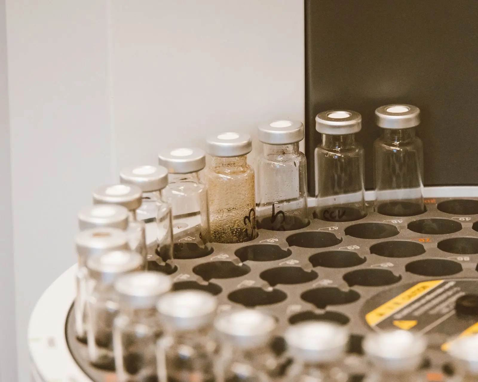 Viales de muestras tapados en la bandeja del inyector automático de un cromatógrafo, en el laboratorio